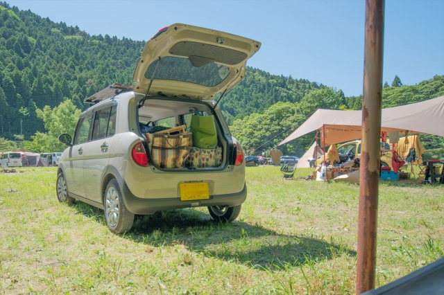 ラゲッジスペースに荷物が積まれたキャンプ場の軽自動車